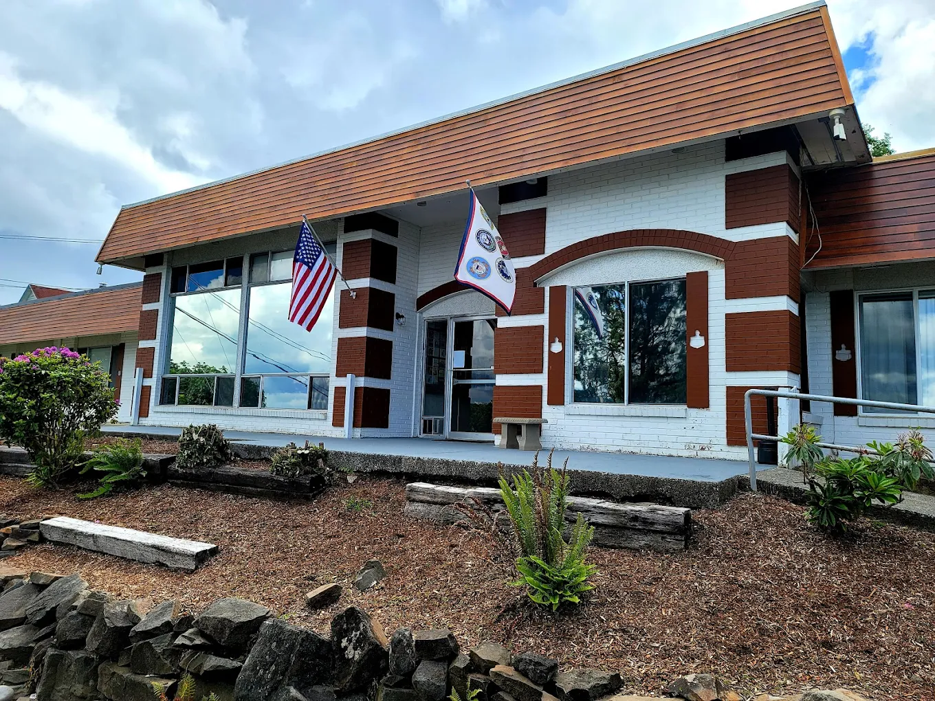 Brick and white building entrance with American flags