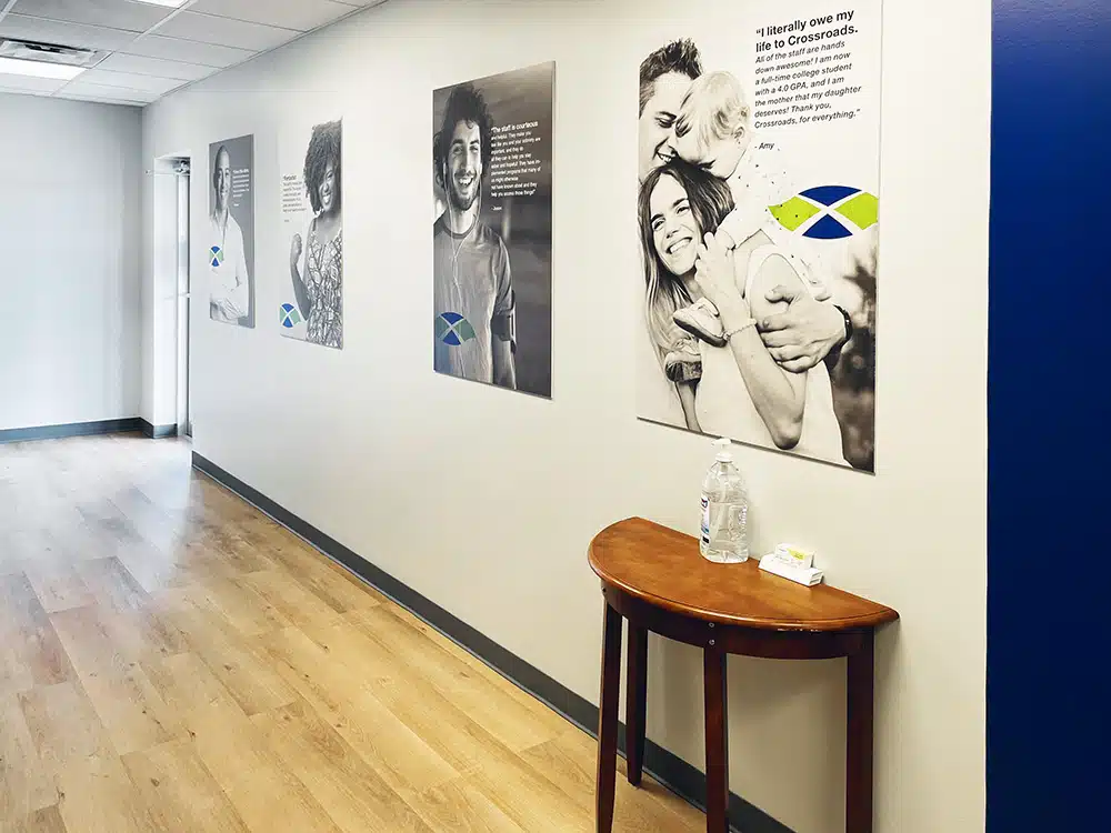 Hallway with framed portraits and recovery messages on wall