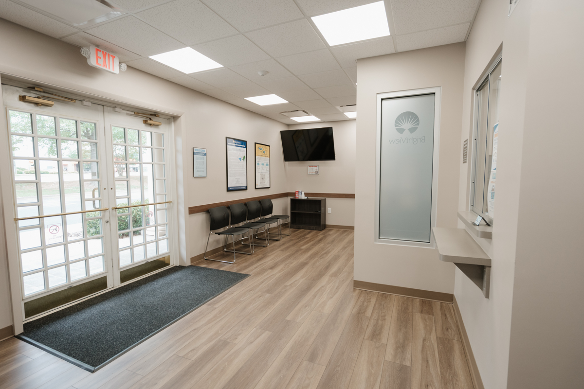 Waiting area with chairs, television, and glass entrance doors