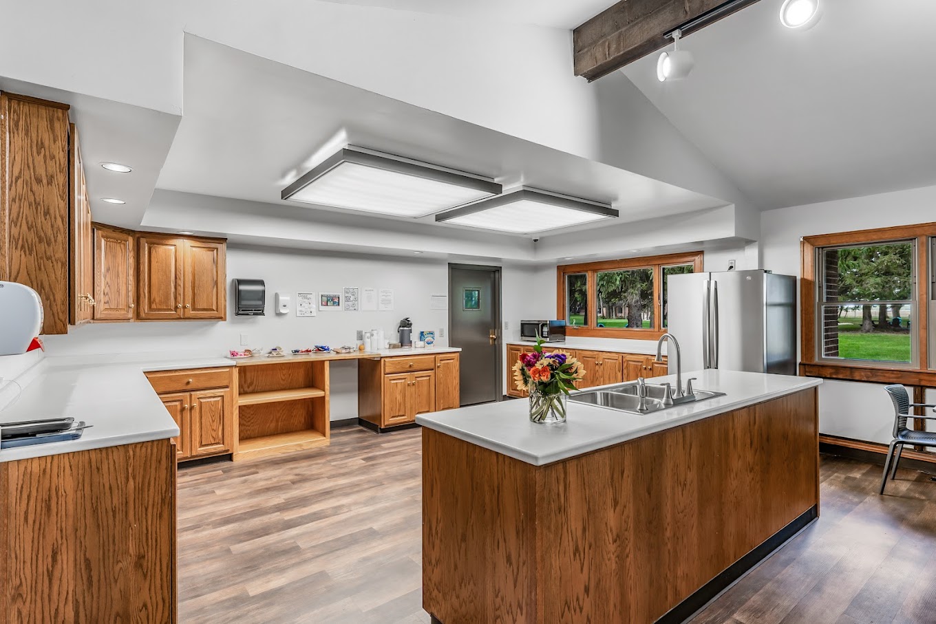 Spacious kitchen with wooden cabinets and an island sink.