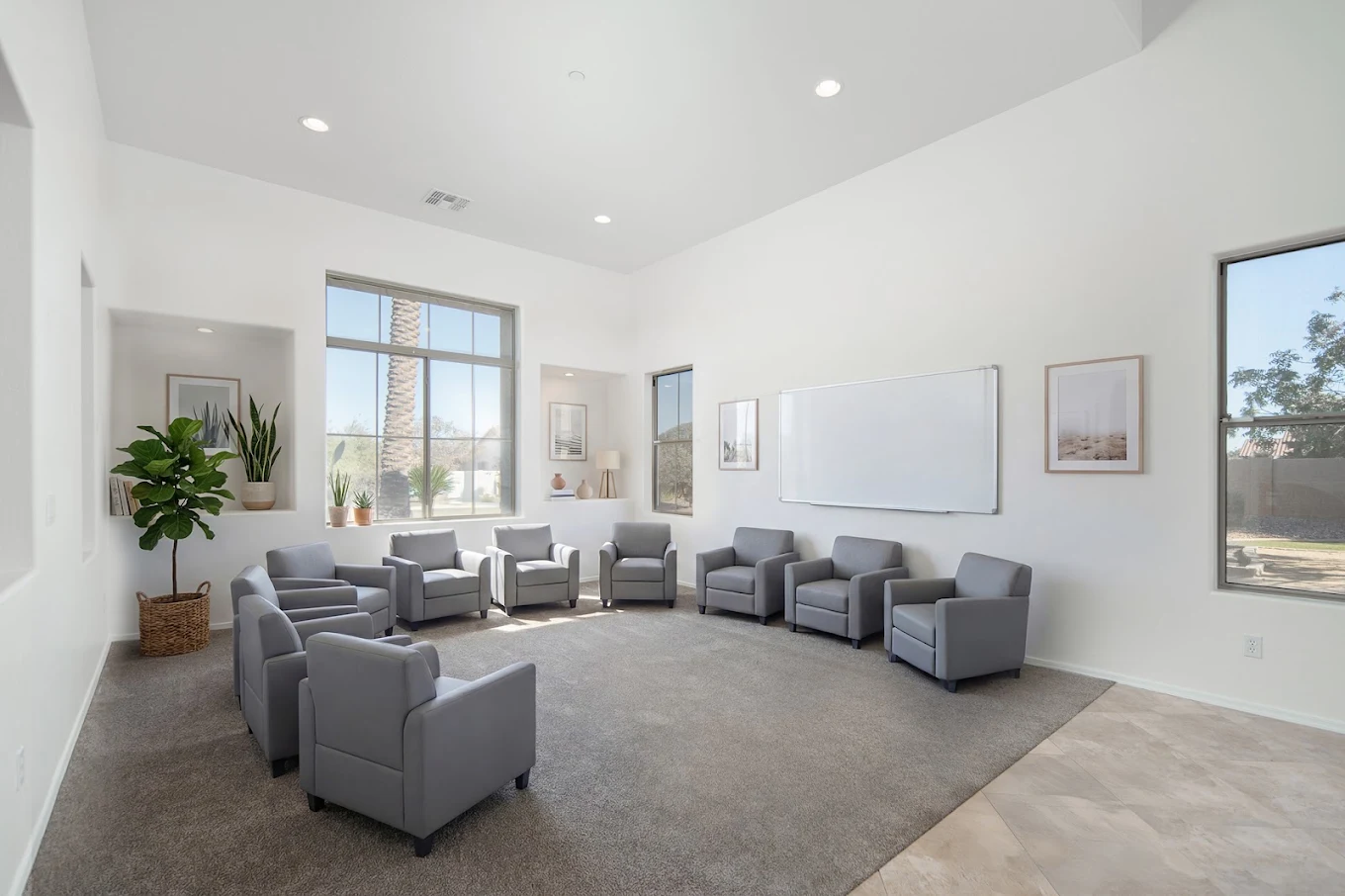 Bright group therapy room with upholstered chairs arranged in a circle