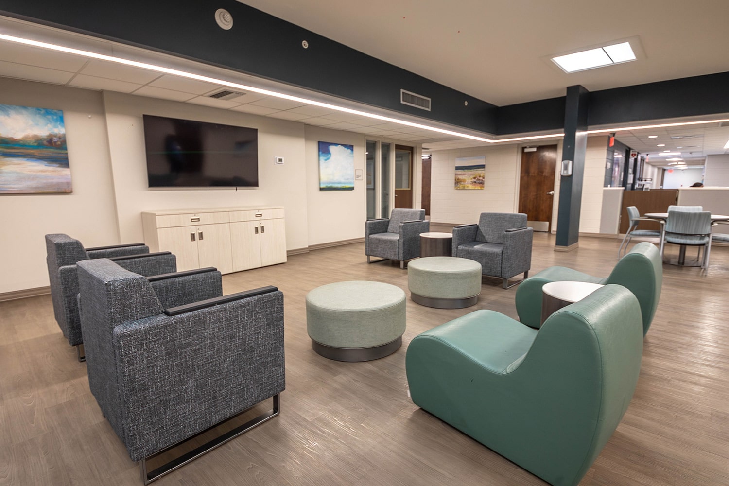 Modern lounge with chairs, tables, and flat-screen TV