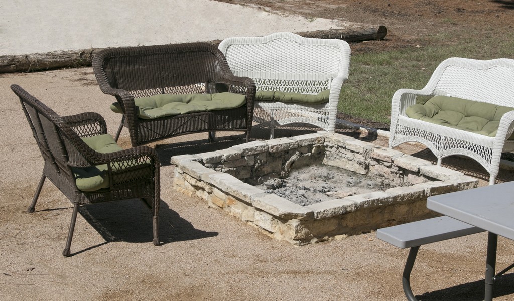 Outdoor seating area with a stone fire pit.