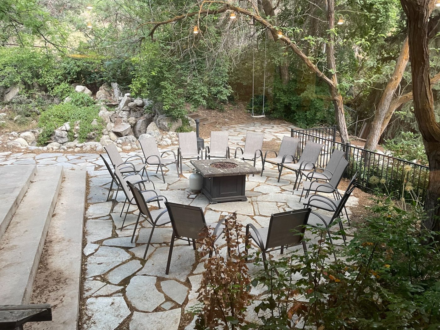 Stone patio with chairs around fire pit