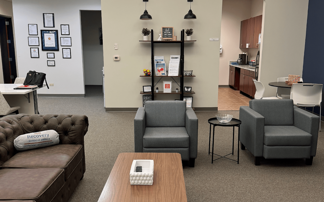 Waiting area with sofas, armchairs, tables, and wall decor