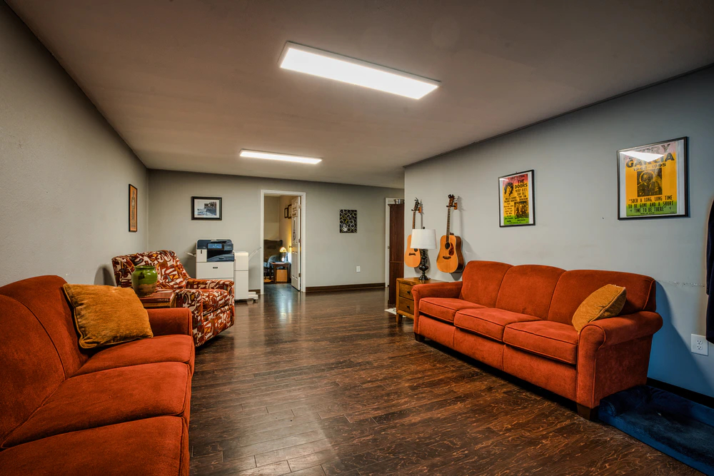 Common lounge with orange sofas, patterned chairs, and artwork
