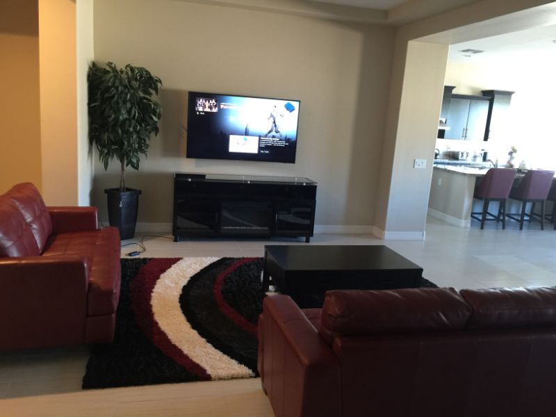 Red leather couches facing wall-mounted TV