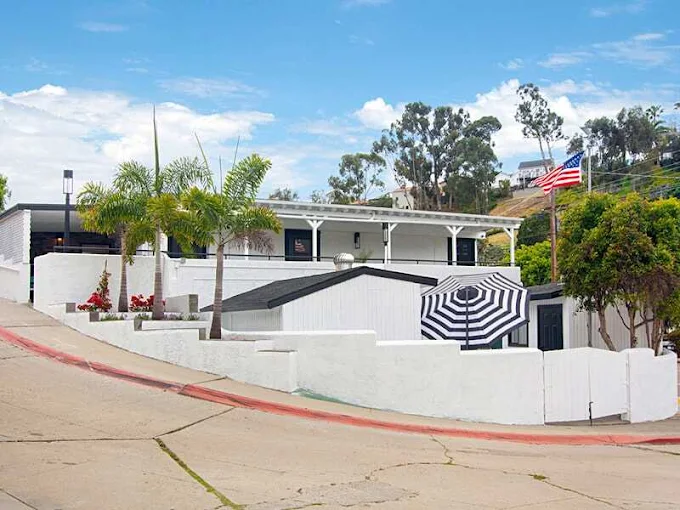 Hillside rehab facility with palm trees and outdoor patio