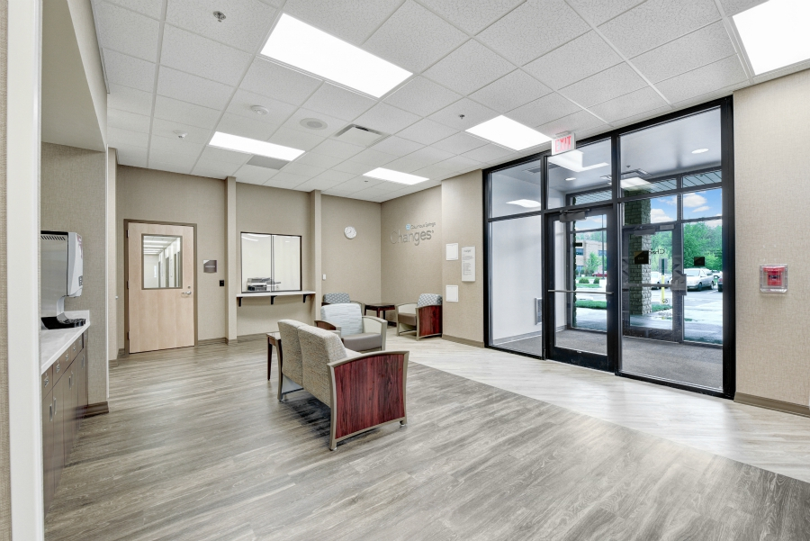 Lobby with seating near glass entrance and reception window