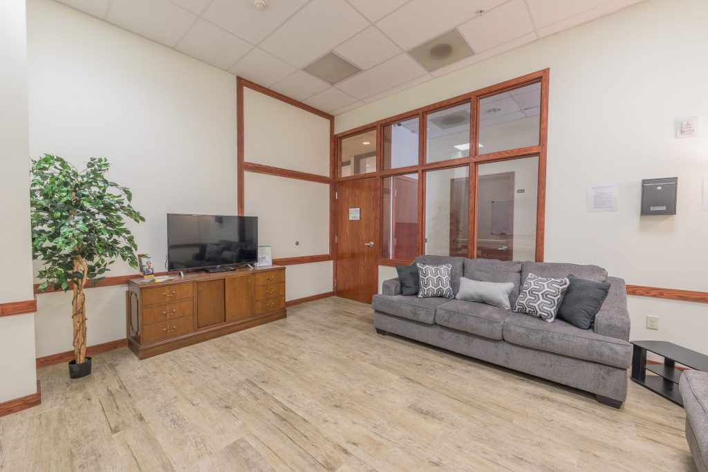Lounge area with sofa, TV, and wood decor accents