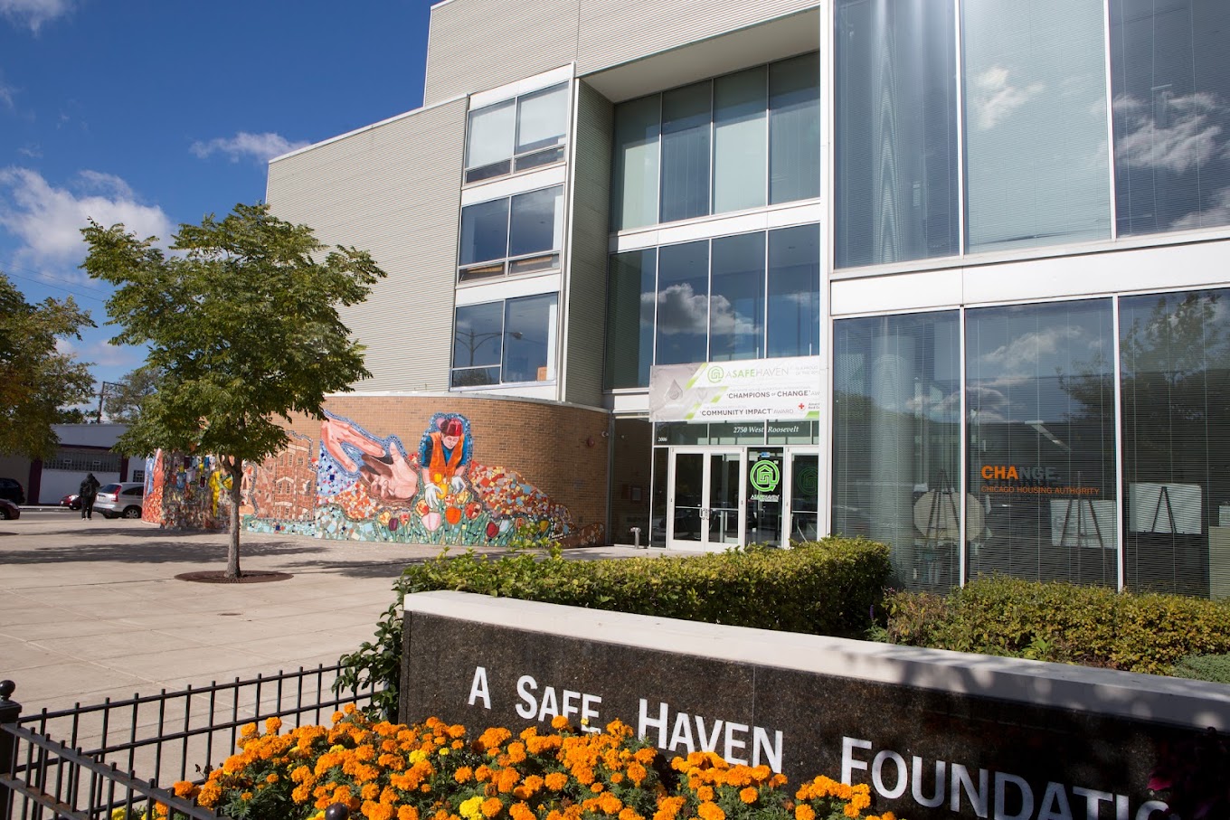 Glass building entrance with flowers and A Safe Haven sign