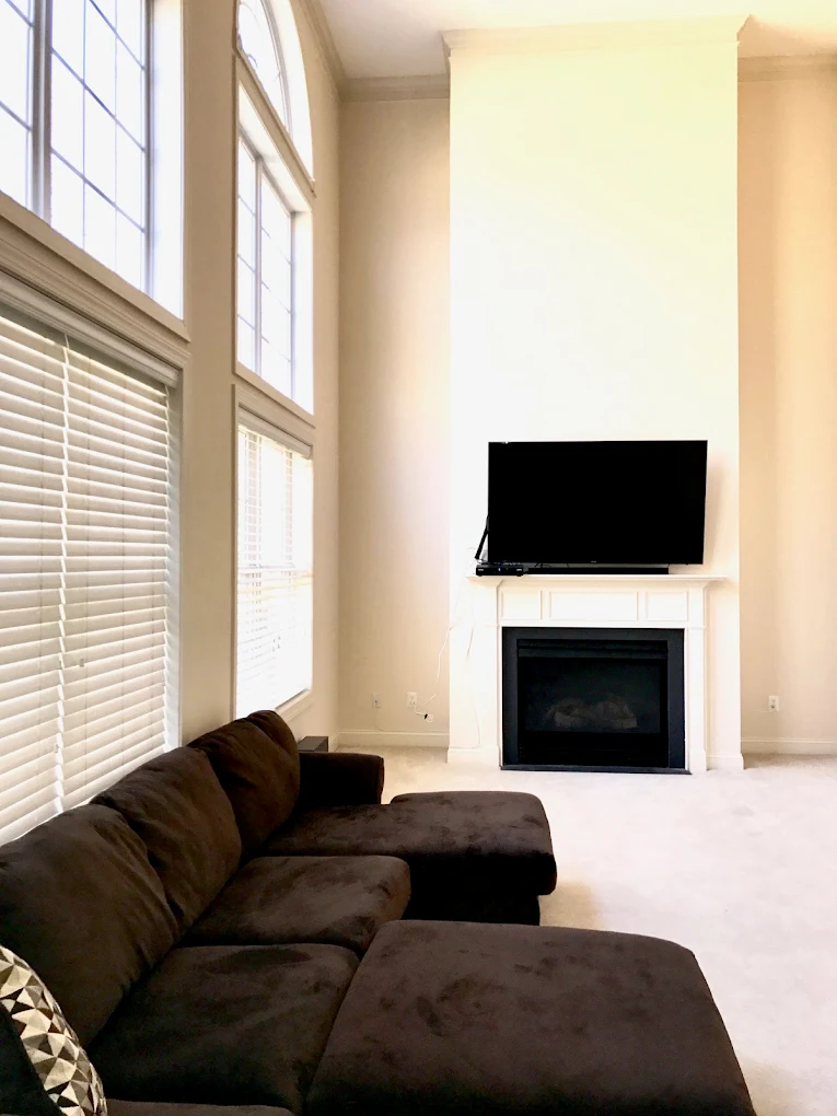 Spacious living room with sectional sofa and fireplace TV.