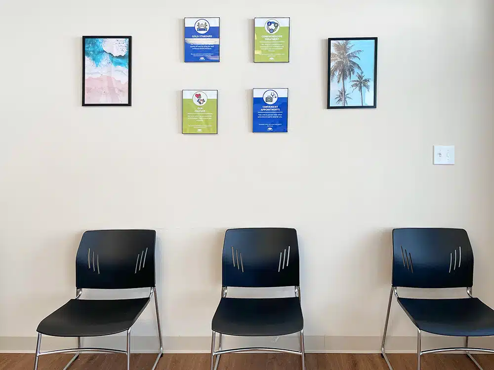 Chairs lined against wall with framed posters above