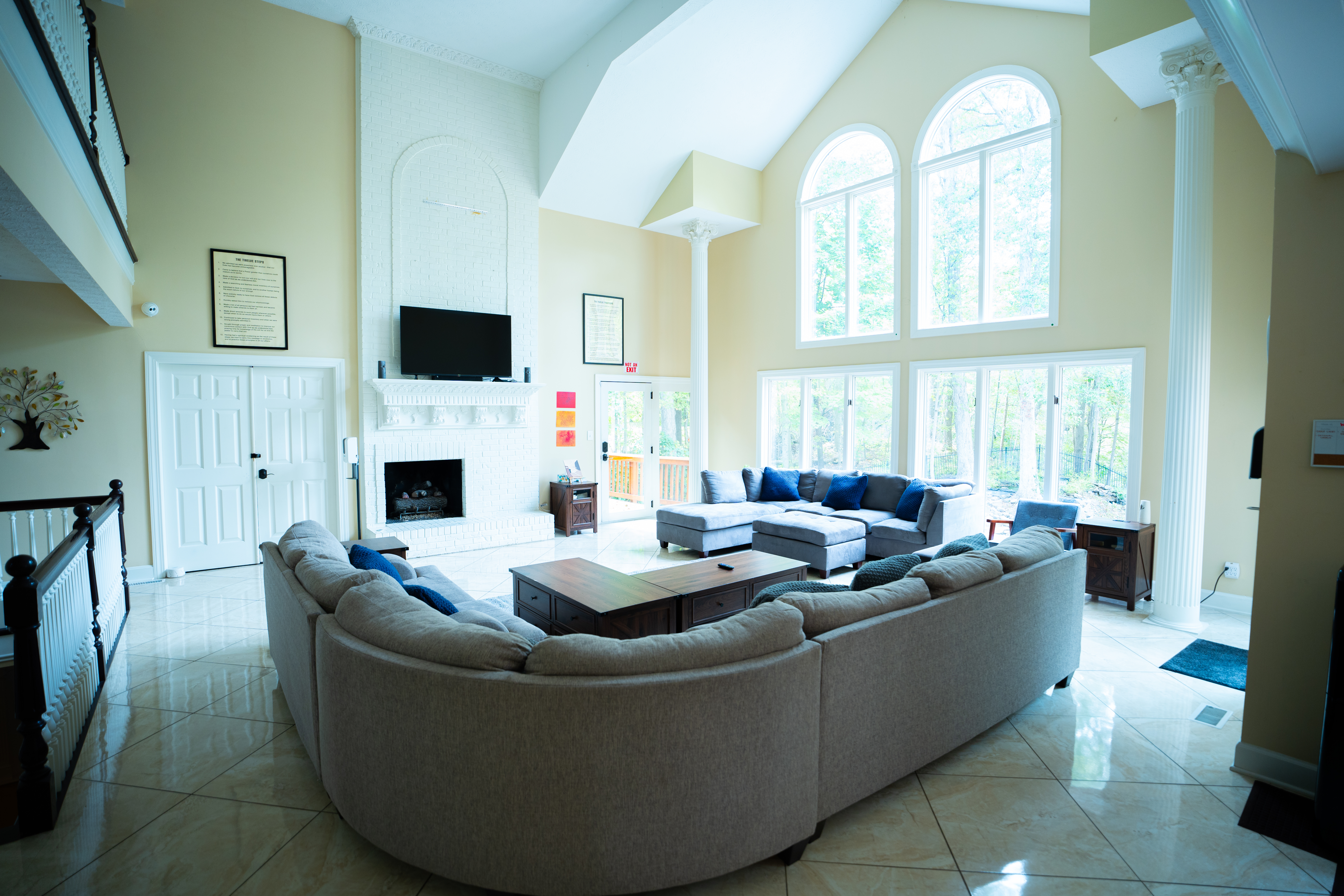 Bright living room with sectional couches and tall windows