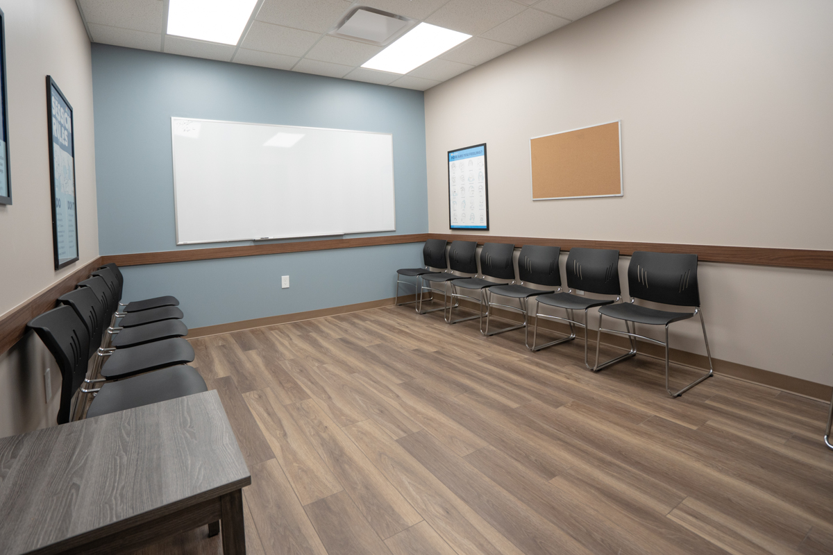 Group room with rows of chairs, whiteboard, and bulletin board
