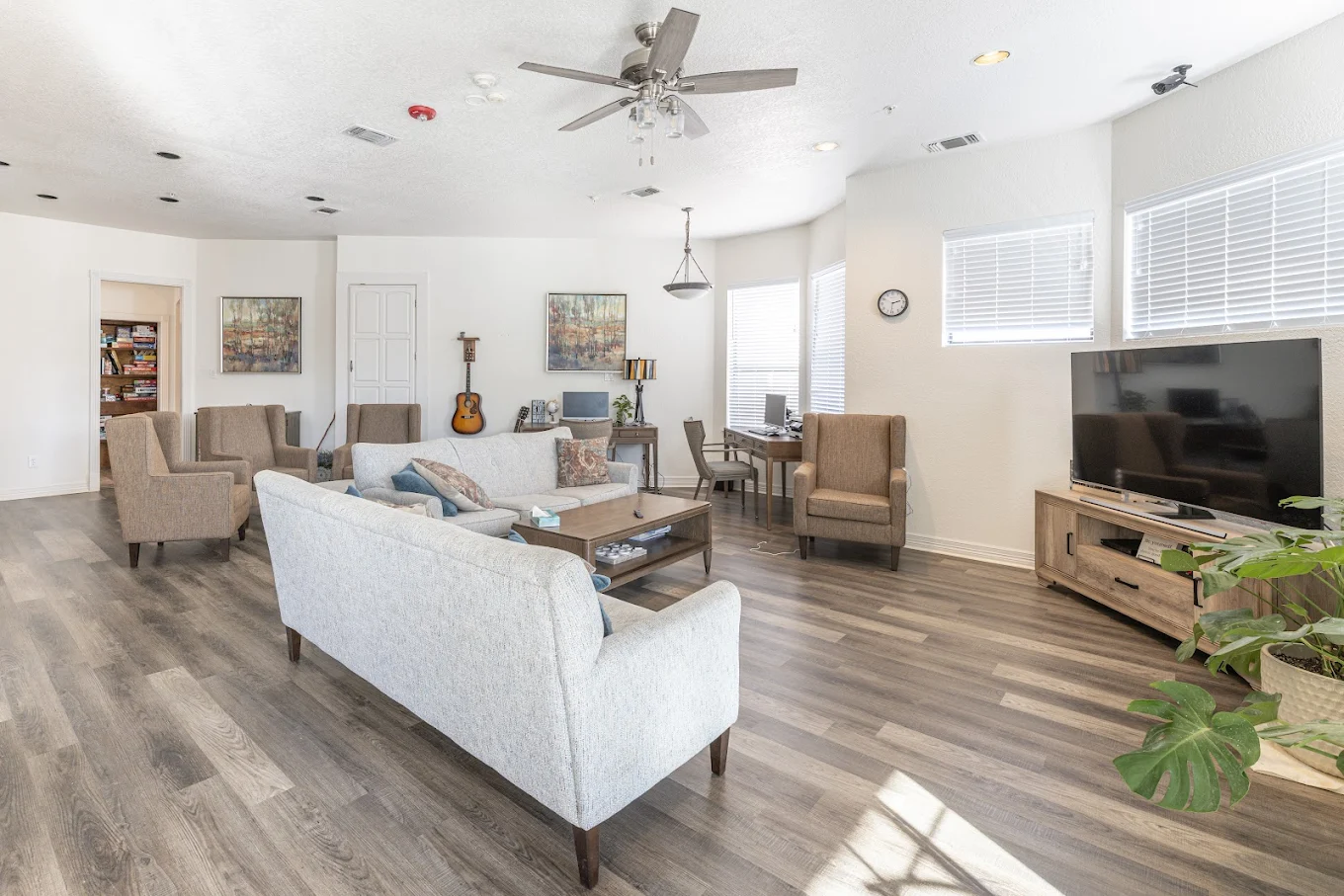 Living room with sofas TV chairs and desk workspace