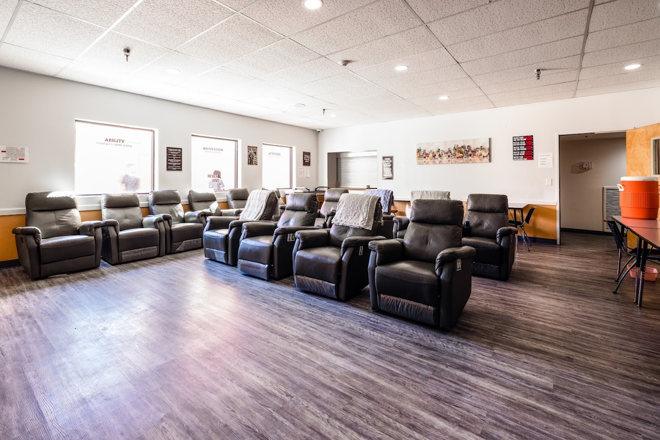 A waiting area with black recliner chairs arranged in rows.