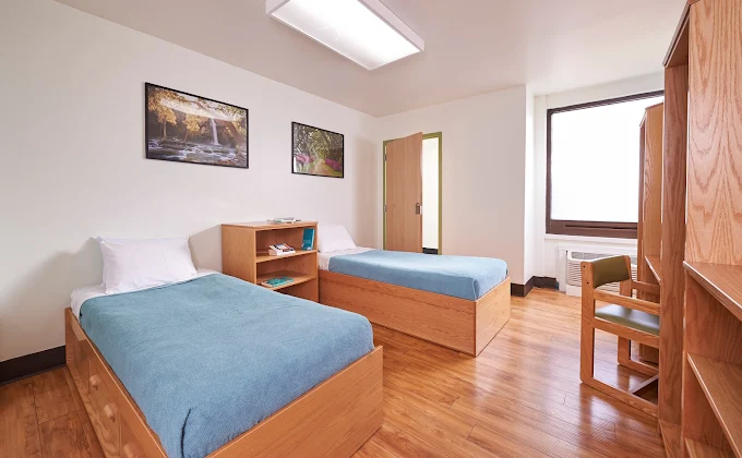 Two beds with wood furniture and natural light