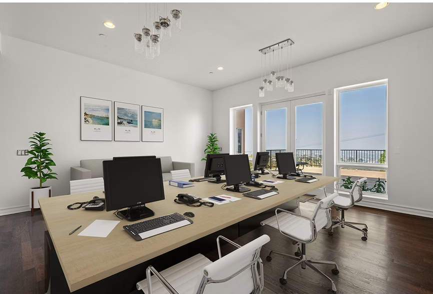 Modern office with desks, computers, and large windows