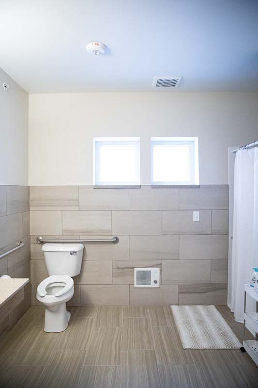 Accessible bathroom with toilet, shower, and grab bars