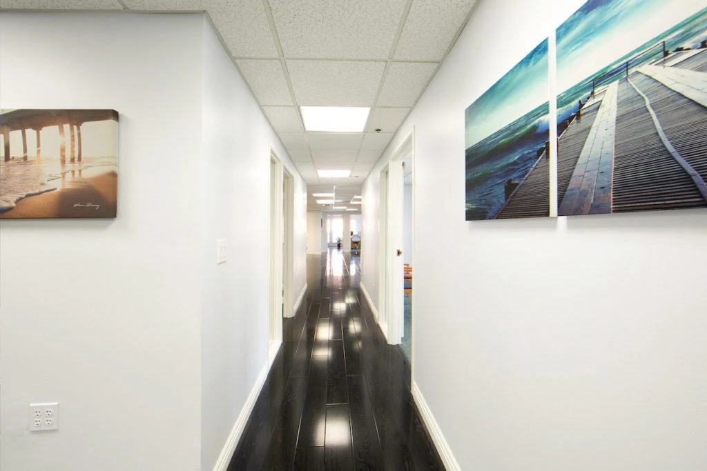 Long hallway with bright walls and coastal artwork