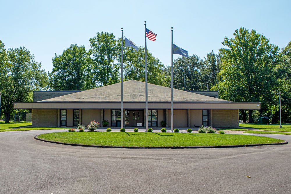 Main entrance with flagpoles and landscaped roundabout
