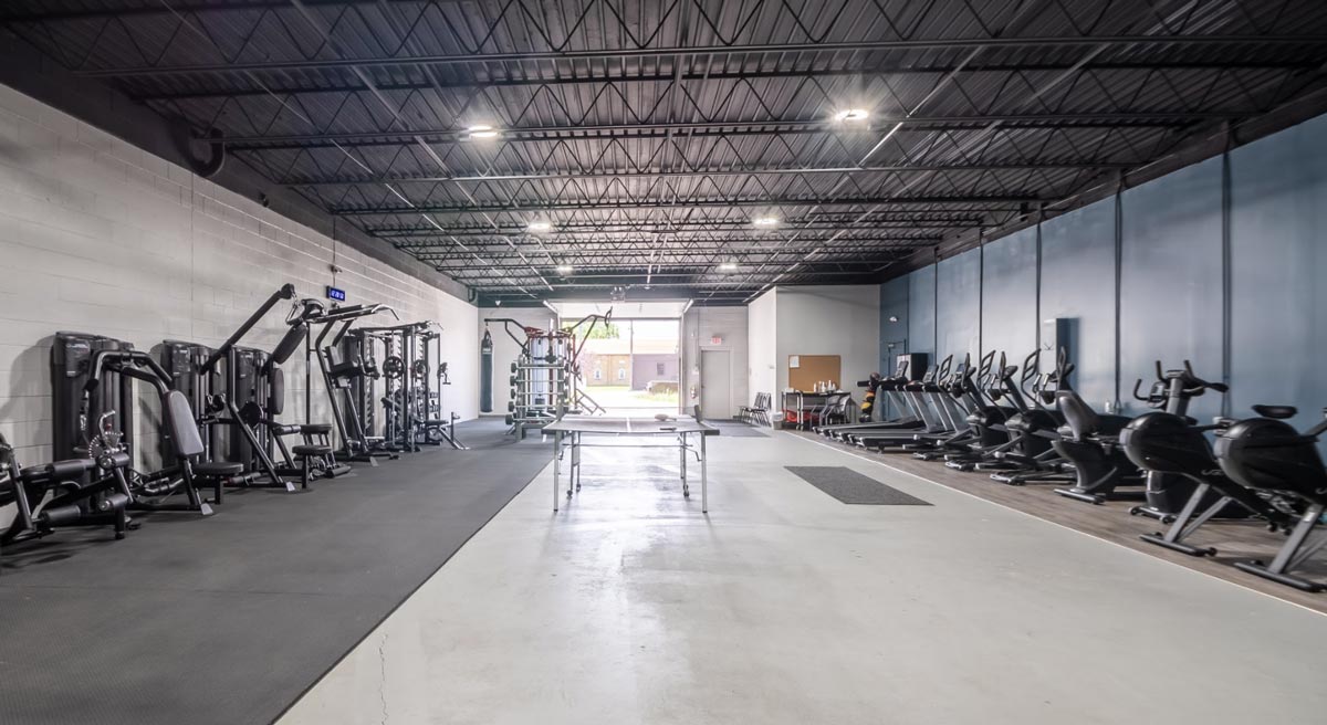 Gym with treadmills, weights, and a ping pong table