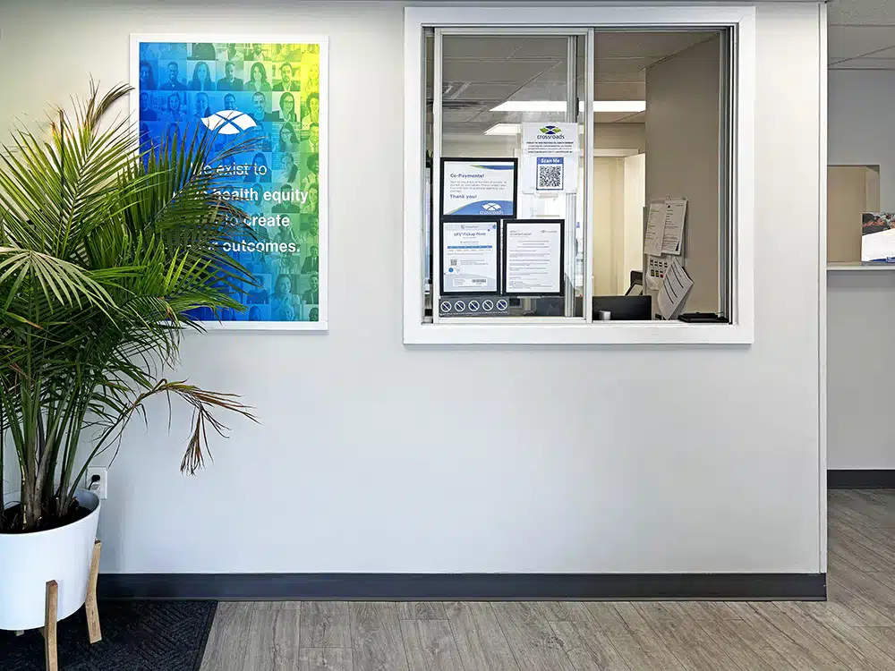 Check-in window with posted notices and nearby plant