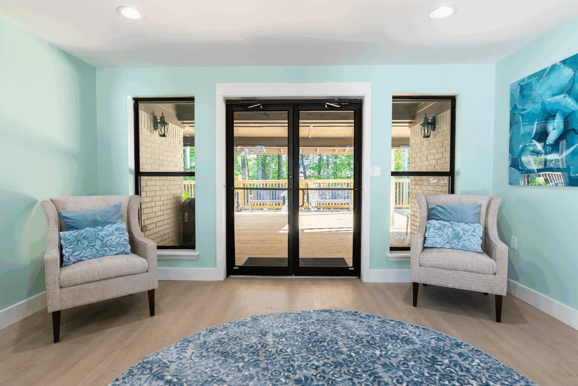Calm seating area with armchairs facing a deck view.