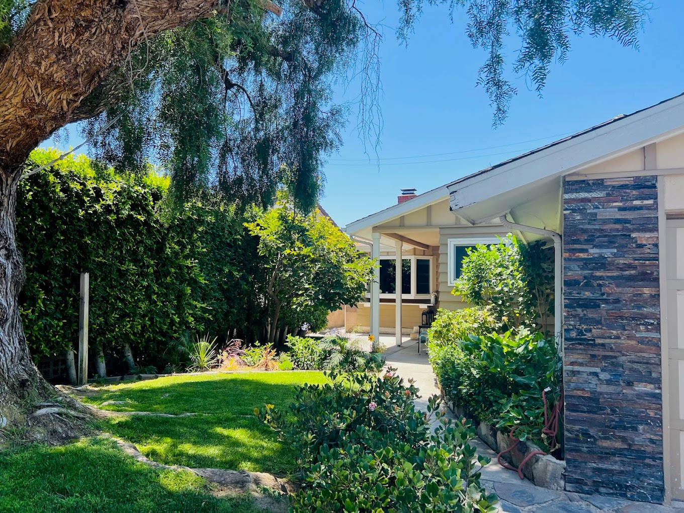 Lush green backyard with a shaded patio area.