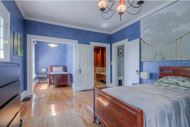 Spacious bedroom with two beds and wood floors