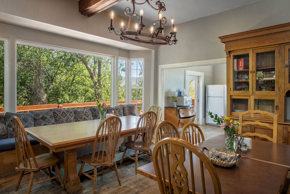 Dining area with a large window, tables and chairs.