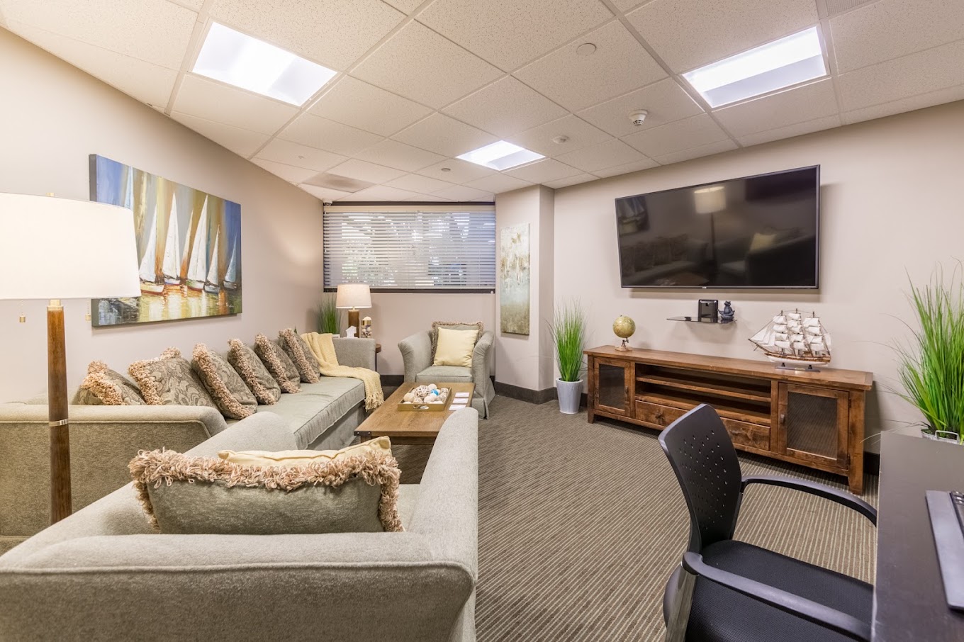 A cozy lounge with sofas, a TV, and nautical-themed décor