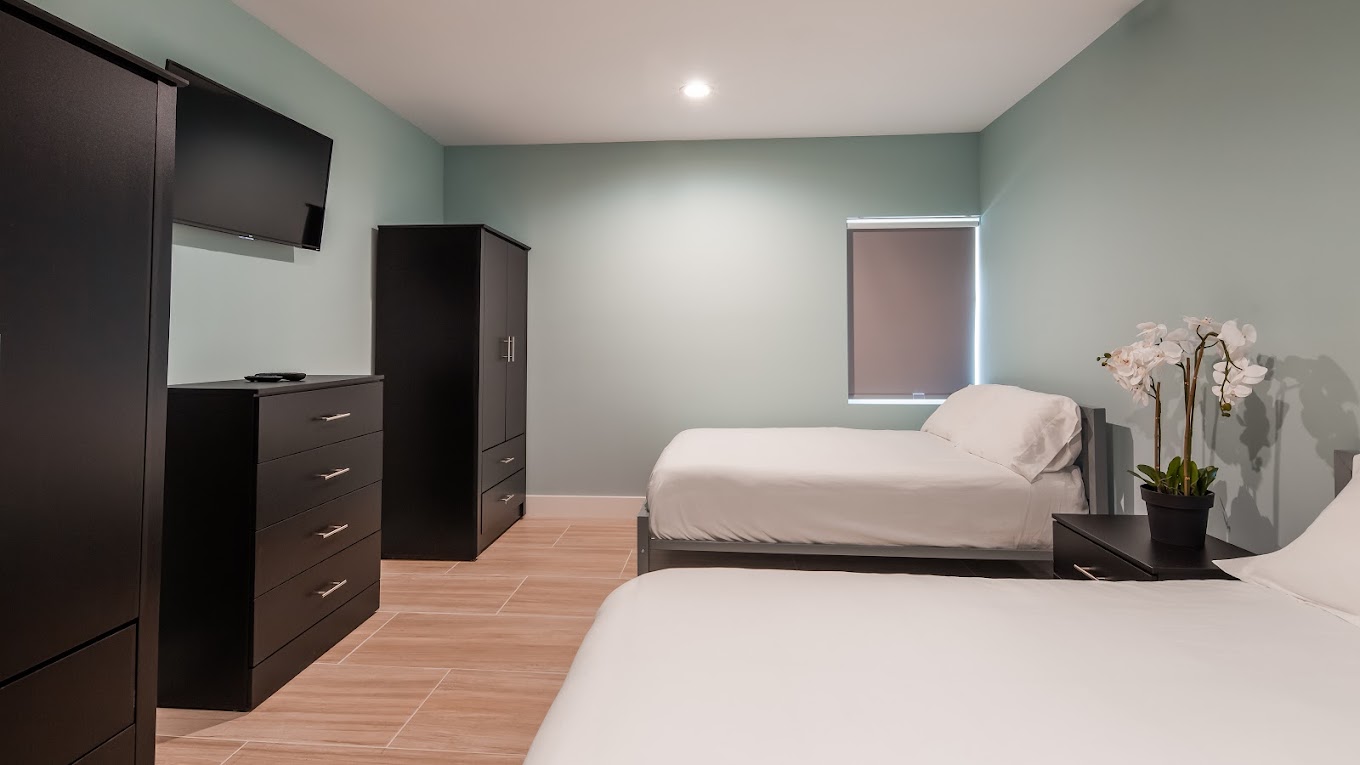 Shared bedroom with two beds, furniture, and a TV.