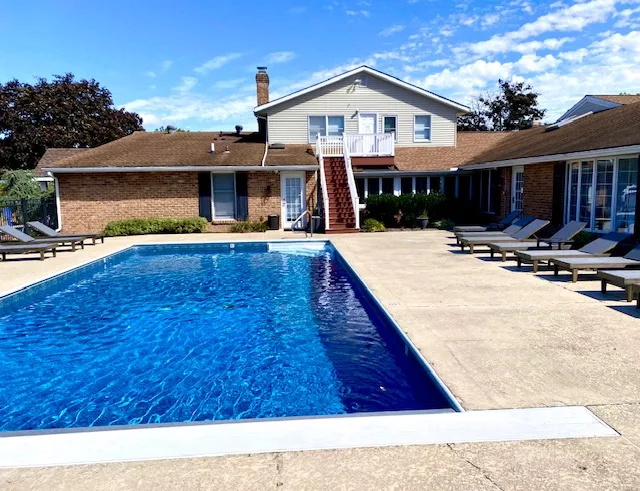 Outdoor swimming pool with lounge chairs and blue sky
