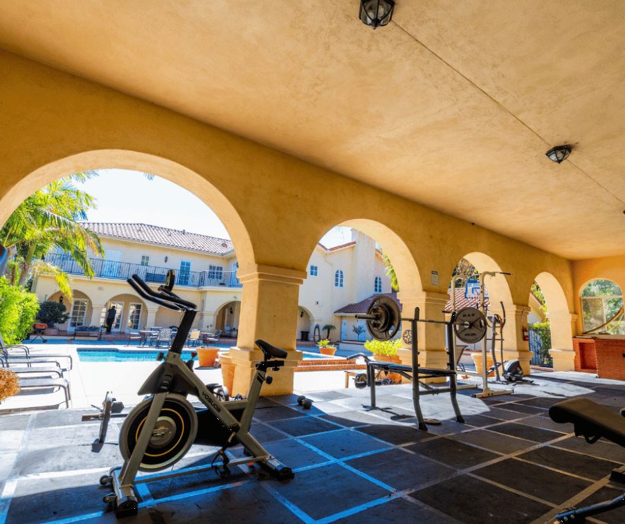 Covered outdoor gym with exercise bikes and weight equipment
