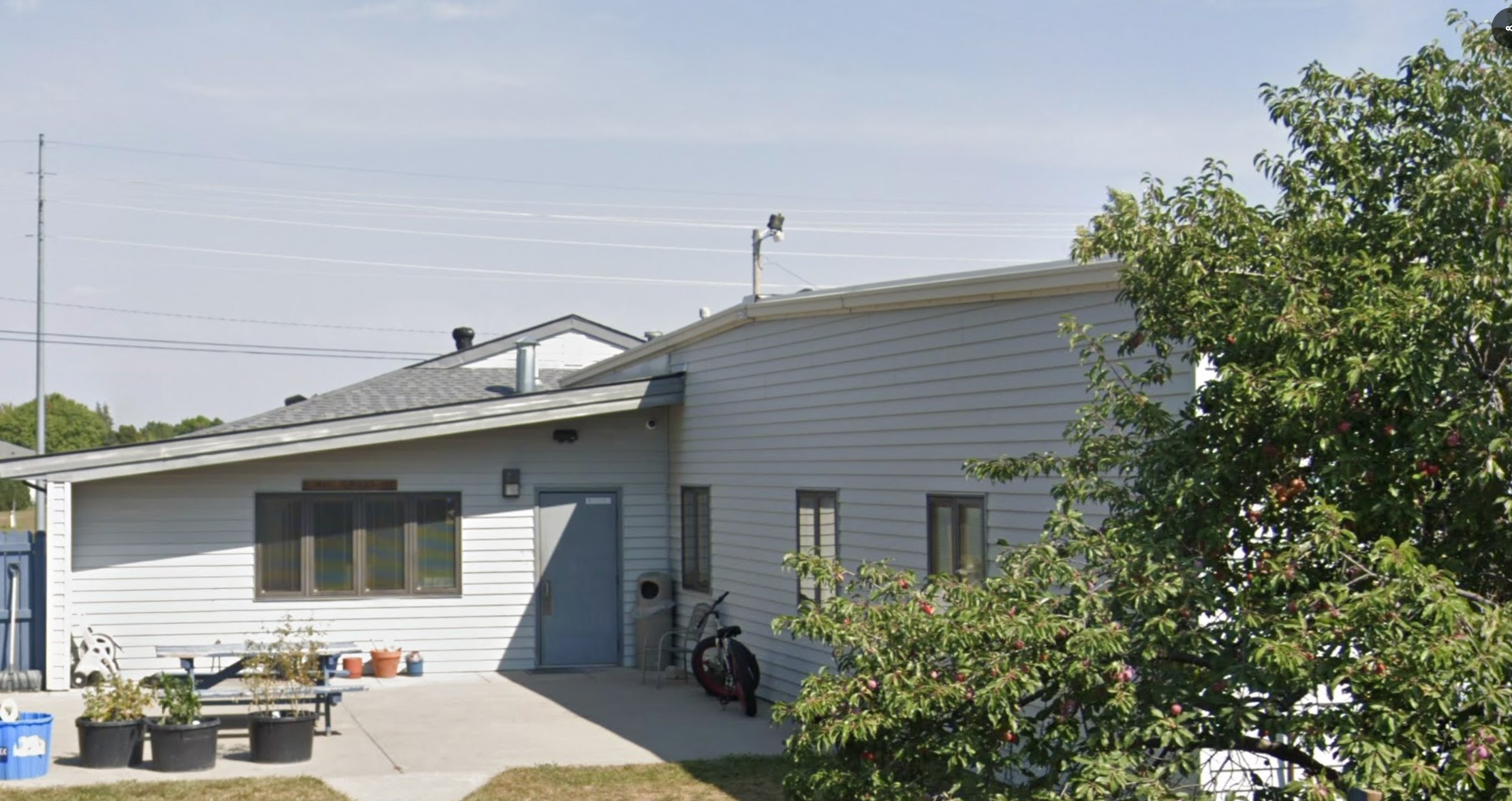 Outdoor patio with potted plants beside facility building.