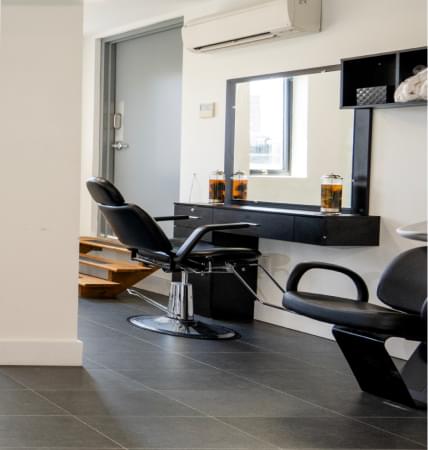 Hair salon setup with chair, mirror, and product jars
