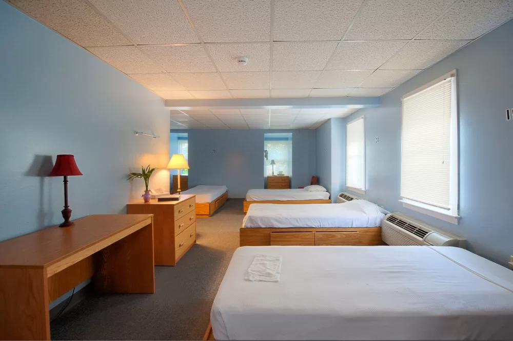 Shared bedroom with multiple twin beds and wooden furniture