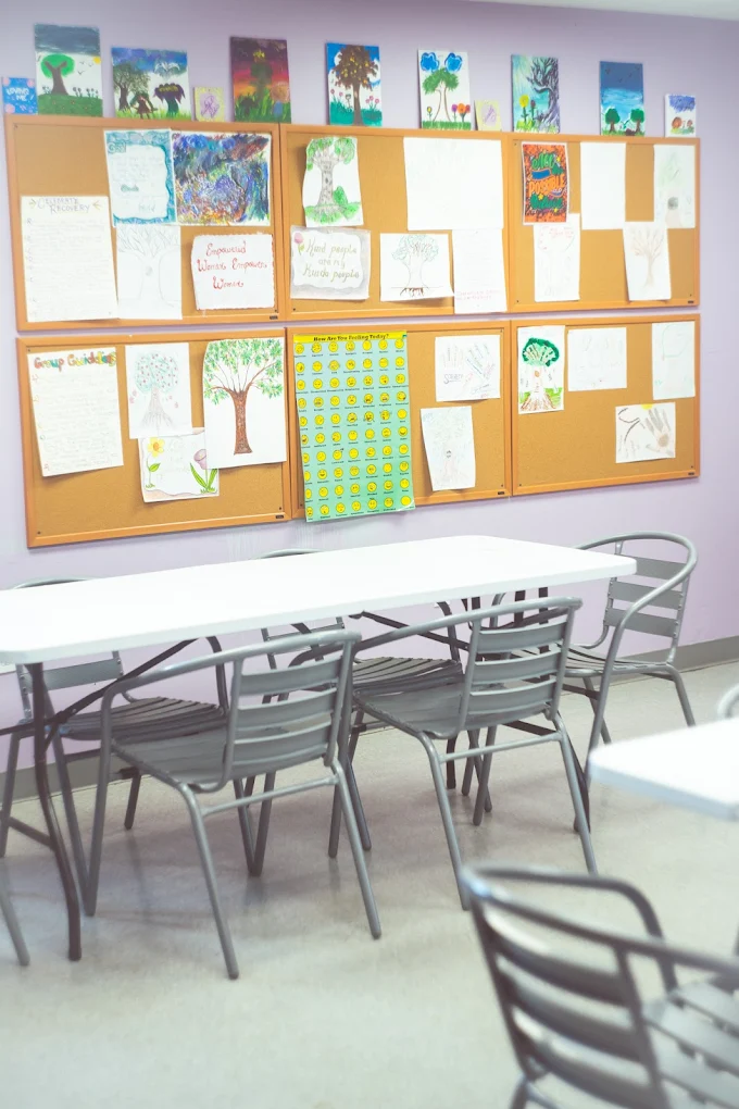 Activity room with tables and recovery artwork on walls