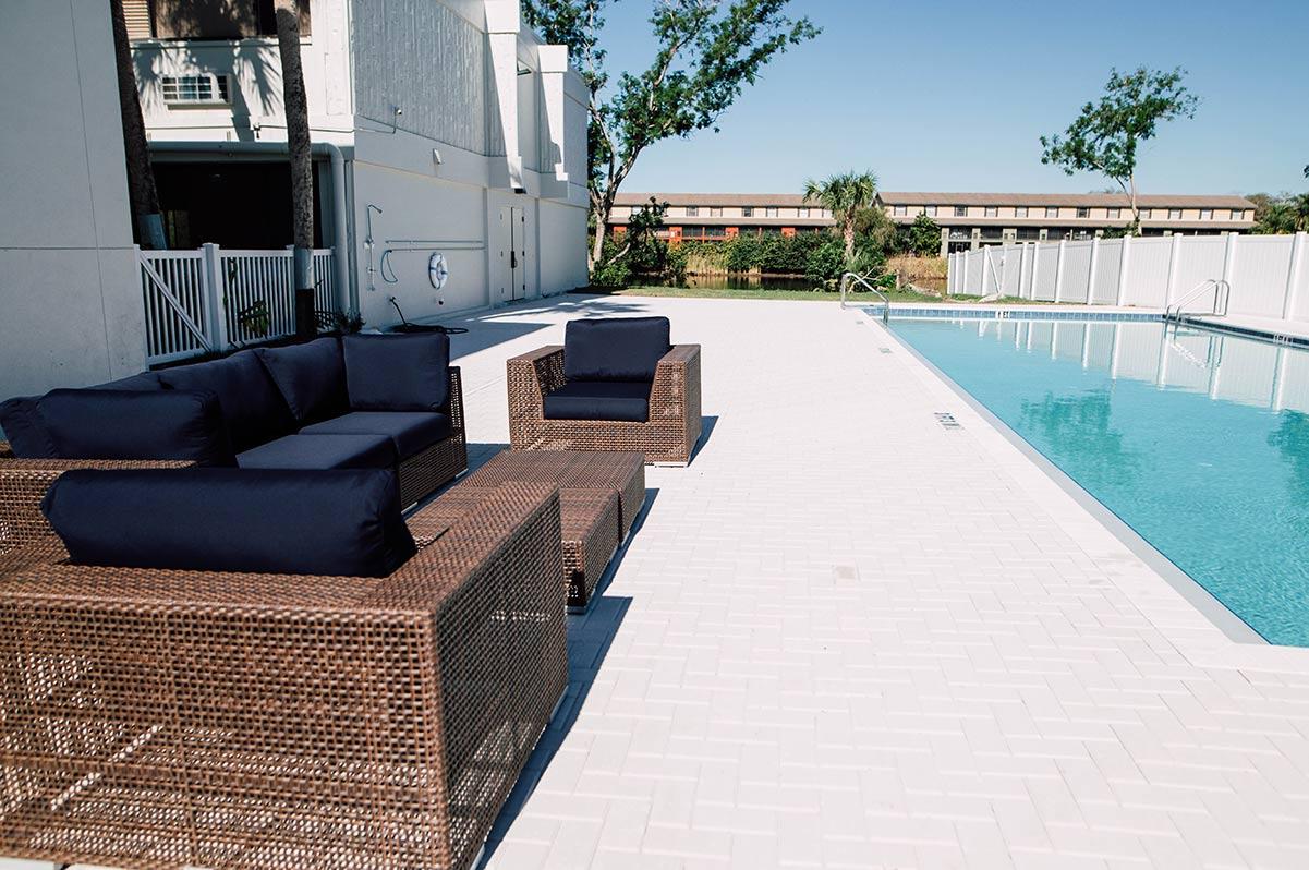 Outdoor pool area with wicker lounge furniture