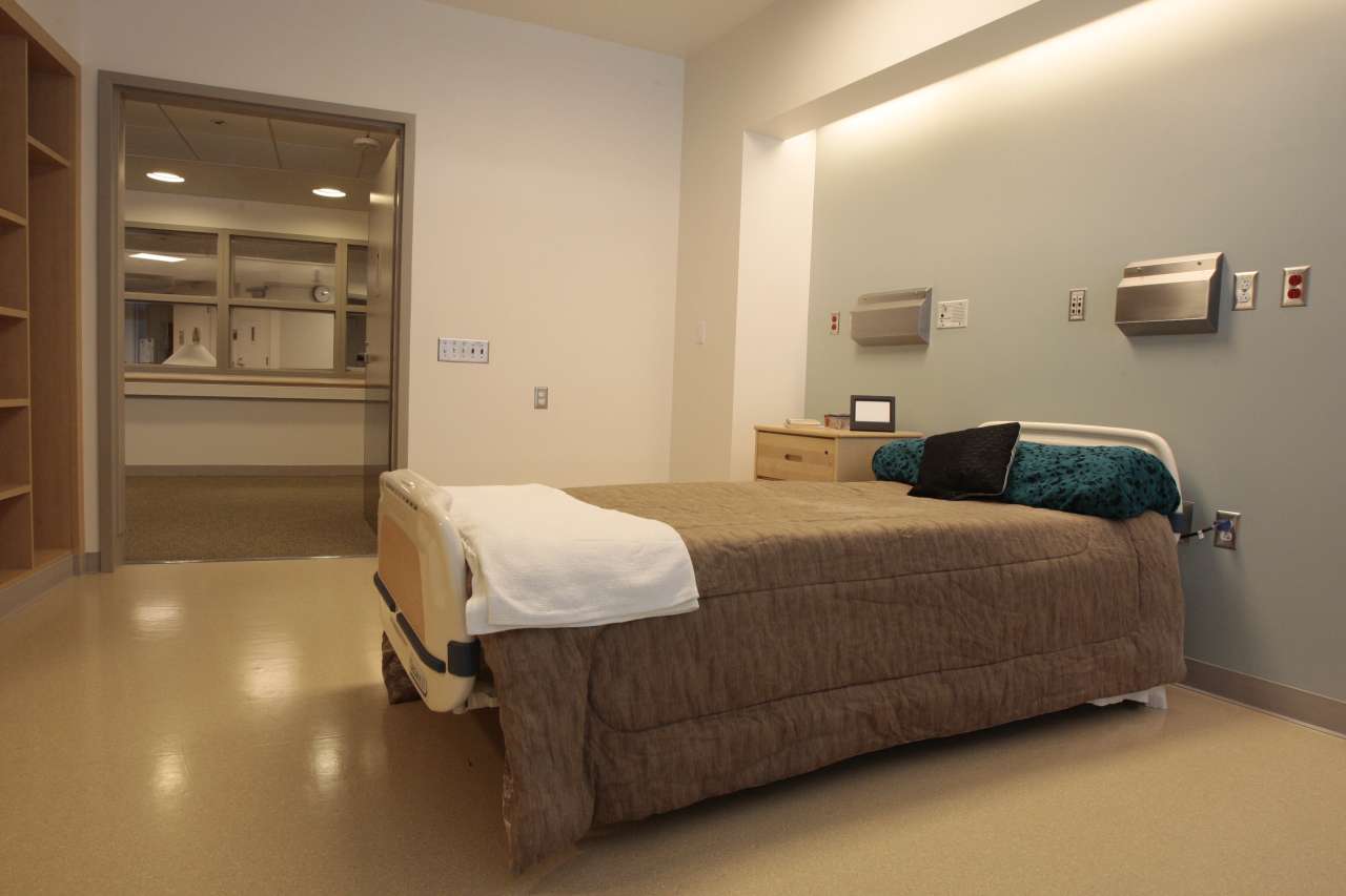 Private patient room with hospital bed and storage