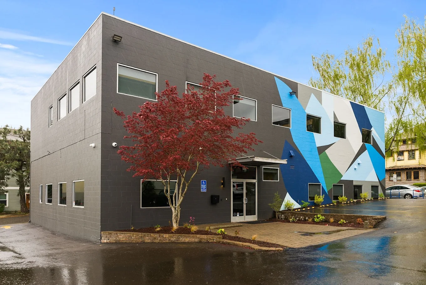 Modern rehab facility building with colorful geometric mural