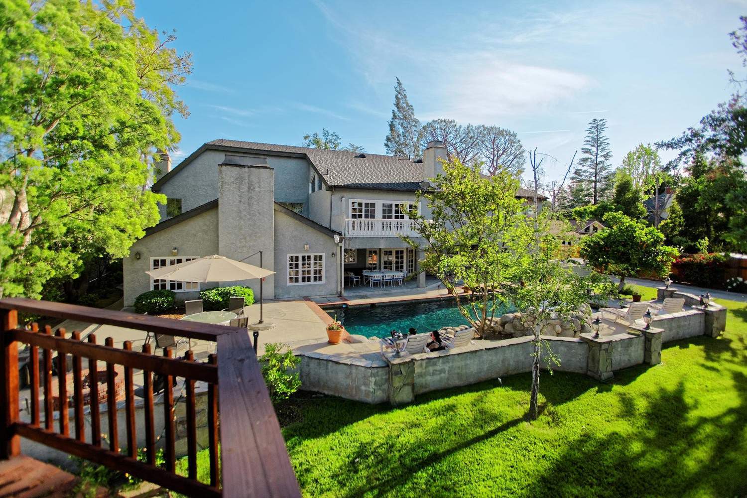 Pool area with loungers and trees in the backyard