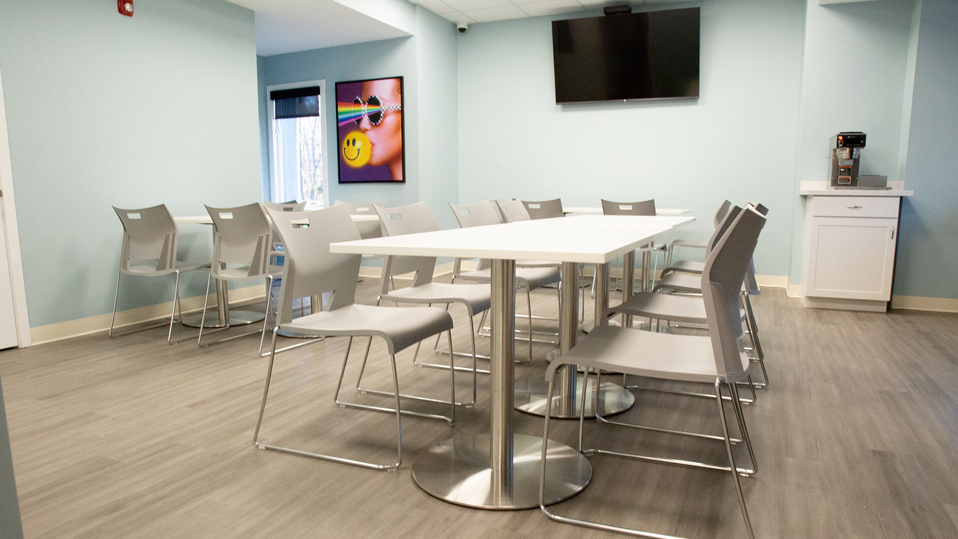 Dining area with tables, chairs and a TV.