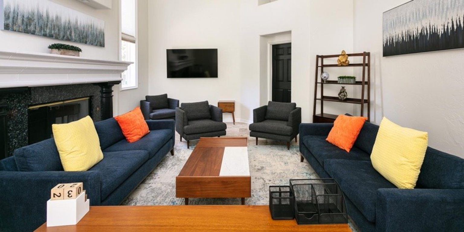Bright lounge with sofas, armchairs, fireplace, and television