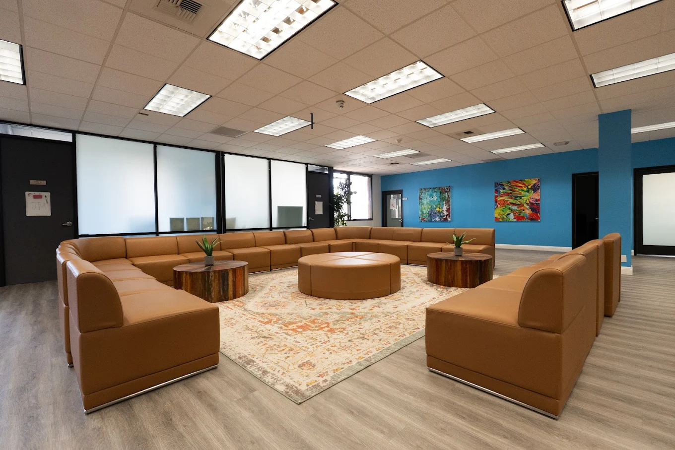 Large brown sectional sofas with tables in bright lounge