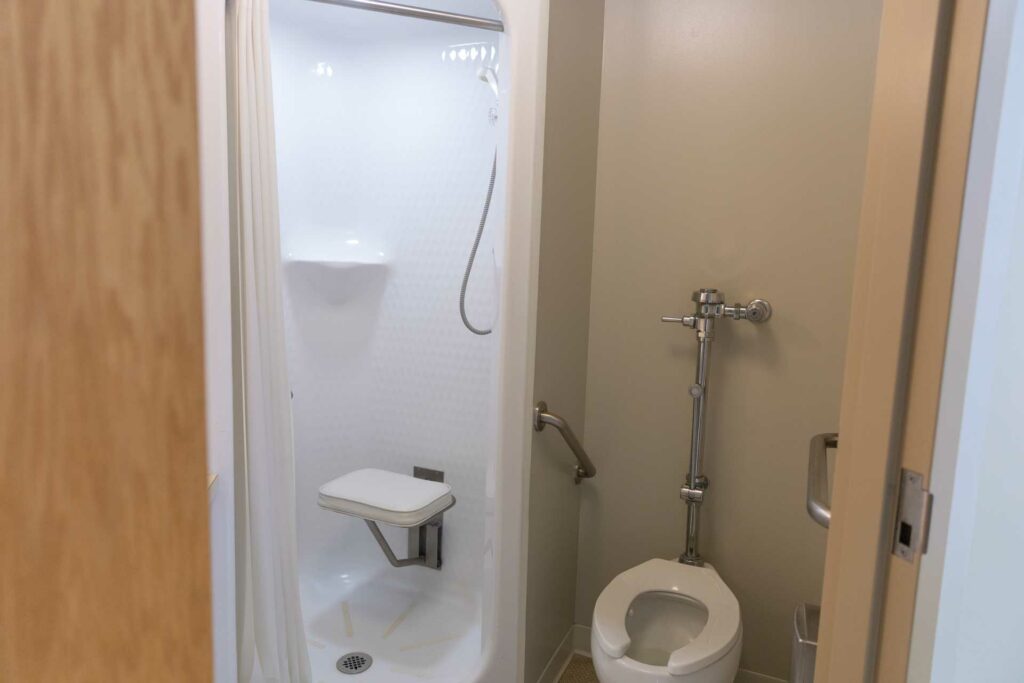 Roll-in shower with seat and adjacent toilet