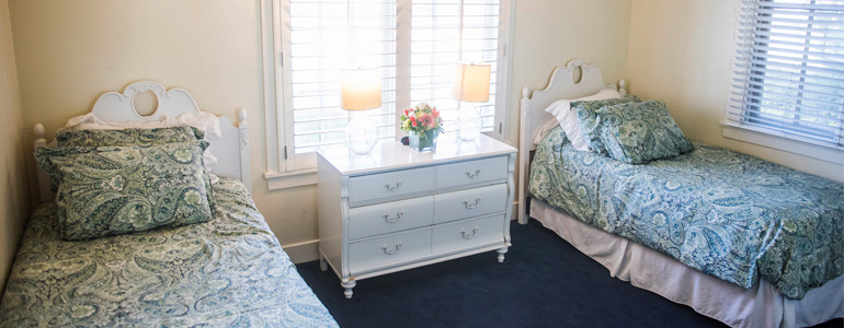Twin beds with patterned bedding and window light