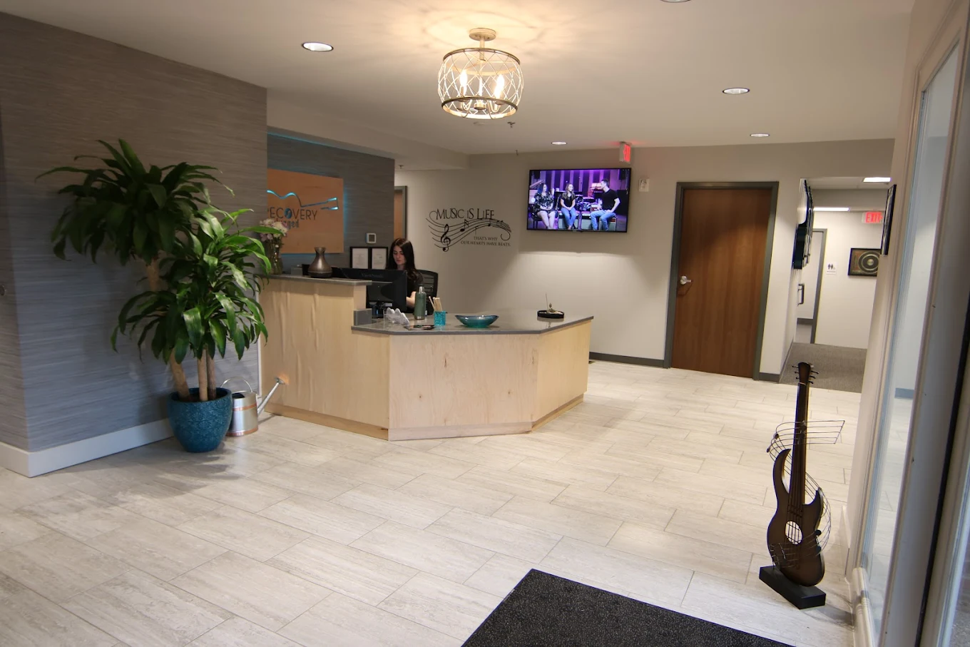 Front desk with TV and plant in a bright reception area